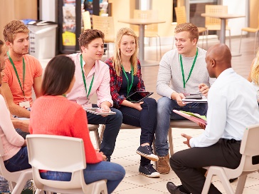 A group of people sitting in a circle and having a meeting.