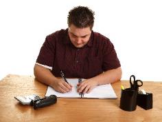 A man filling out a document. 